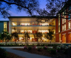 View at dusk of Tulane University Freeman School of Business. Glass walls reveal lights shining through from inside the building.