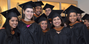 A group of MBA graduates wearing caps and gowns.