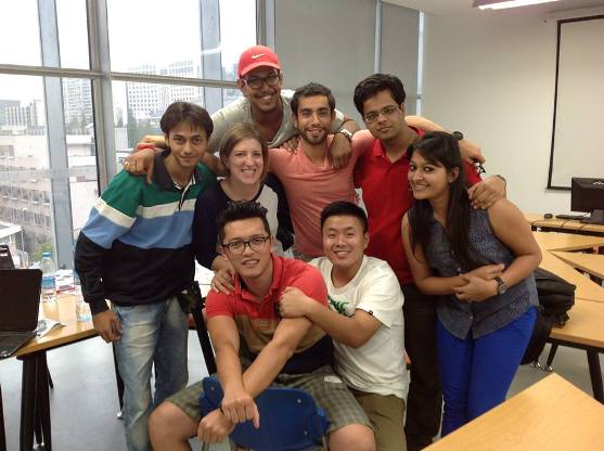 Weatherhead Global MBA program students huddled for a photo in a classroom. 