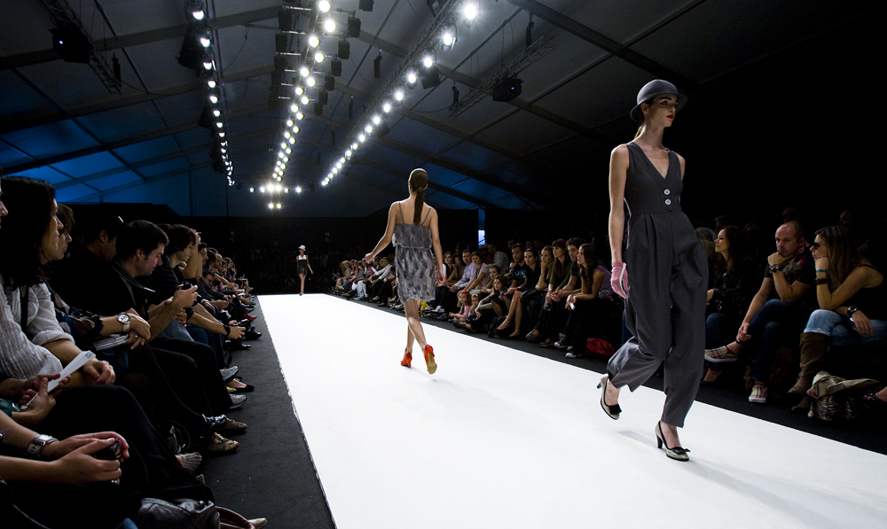 Models walk on fashion show runway.