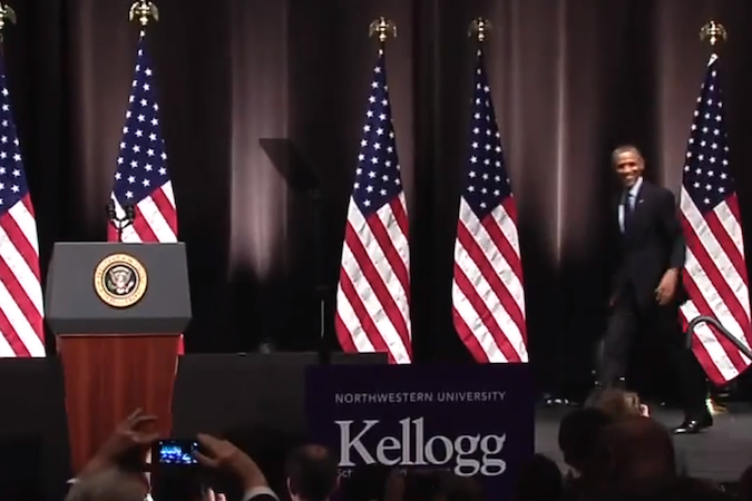 President Obama strolls onto a stage at Northwestern University to address MBA students at Kellogg