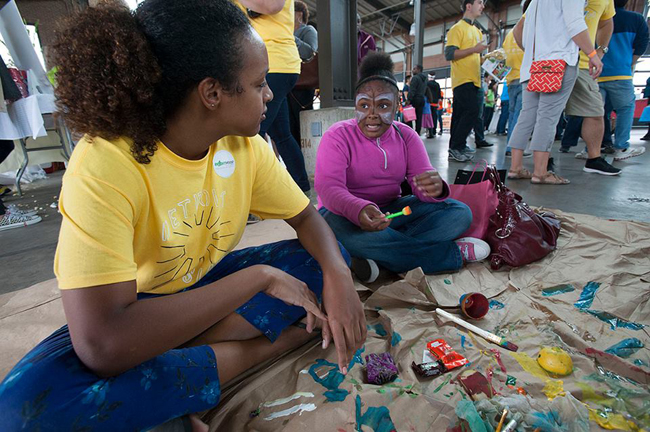 A Michigan Ross School of Business first-year MBA speaks with a youth at the Detroit Youth Maker Faire. Photo courtesy of Michigan's Ross School of Business