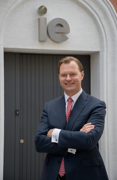 Profile photo of IE Business School Dean Martin Boehm, arms crossed, standing in front of door with "ie" above it.