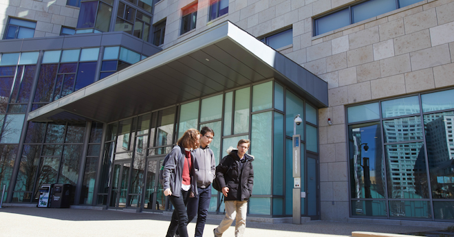 Three male students walking away from MIT Sloan's admissions office.