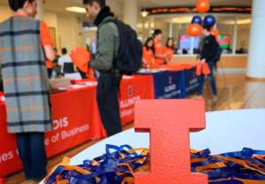 Students gathered around tables decorated in orange and blue for Gies Giving Day. 