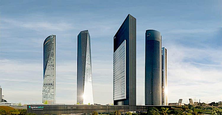 Several realistic-looking modern skyscrapers line an otherwise flat horizon, representing an artist's rendering of IE Business School's new skyscraper campus in Madrid.